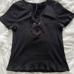 T shirt - Ribbad t shirt med snörning på framsidan från H&M divided, lappen sitter ej kvar men skulle gissa att storleken är s/m.:)