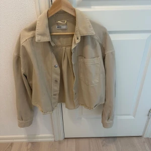 Beige overshirt från G Perfect Jeans - Snygg beige overshirt från G Perfect Jeans i storlek S. Jackan har en avslappnad passform med knappar framtill och en praktisk bröstficka. Perfekt för lager-på-lager-stil under vår och höst.