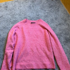 Rosa stickad tröja från Vero Moda - Säljer en mysig rosa stickad tröja från Vero Moda. Tröjan har en enkel design med långa ärmar och ribbade kanter vid ärmslut och nederkant. Perfekt för kyliga dagar. 💖