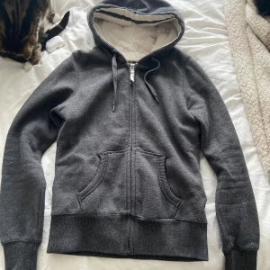 Grå zip up hoodie från H&M - Mysig grå hoodie från H&M med fluffigt foder och dragkedja framtill. Storlek S men skulle säga att den är mer som en xs. 