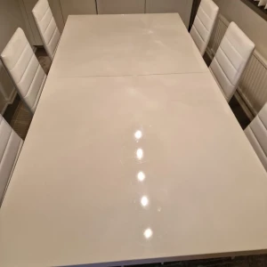 Vit matbord med sex stolar - Elegant vit matbord med ett stort bord och sex matchande stolar. Bordet har en blank yta och stolarna är klädda i vitt material med vadderade ryggstöd. Upphämtning endast! Stolarna ingår i priset
