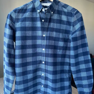 Homebound oxfordskjorta blårutig skjorta, storlek S - Blårutig oxfordskjorta från Homebound. Slim fit, storlek S. 100% bomull. Mycket fint skick. Button down. Jag säljer många skjortor i samma storlek, kolla gärna på mina övriga annonser för att skapa ett paket. Axelbredd: 42 cm Längd: 72 cm  Casual skjorta, smart, oxford.
