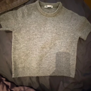 Grå stickad tröja från ZARA - Mysig grå stickad tröja från ZARA med korta armar. Använd ungefär 3 gånger och tvättad är den. Inga defekter eller likande! Storlek S är den. Hör av er om ni har frågor. Pris kan alltid diskuteras.