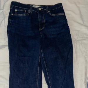Mörkblå jeans med fransade kanter / ZARA - Snygga mörkblå jeans med en klassisk femficksdesign och fransade kanter. De har en rak passform och är perfekta för en avslappnad stil. Jeansen har en knapp och dragkedja framtill.