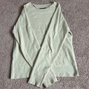 Beige stickad tröja - Mysig beige stickad tröja med ribbade muddar vid ärmslut och nederkant. Perfekt för kyligare dagar och enkel att matcha med olika outfits.