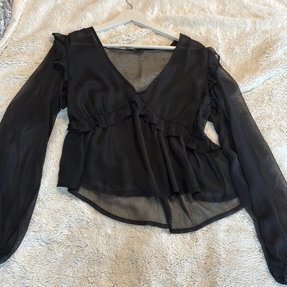 Svart blus med volangdetaljer