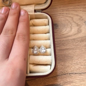 Glittriga droppformade örhängen - Snygga droppformade örhängen med glittrande stenar. Perfekta för att ge en elegant touch till din outfit. De har en vacker silverfärg och är idealiska för speciella tillfällen.