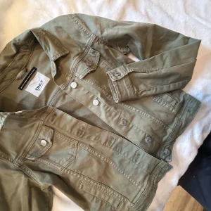 Olivgrön jeansjacka från ONLY - Säljer en snygg olivgrön jeansjacka från ONLY. Jackan har en klassisk design med knappar framtill och två bröstfickor. Perfekt för en avslappnad stil.