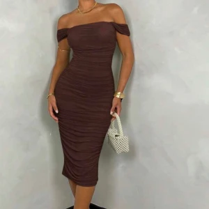 Brun offshoulder klänning - Snygg brun offshoulder klänning med åtsittande passform. Klänningen har en rynkad design som ger en elegant look. Perfekt för en kväll ute eller en speciell tillställning. Storlek Xs