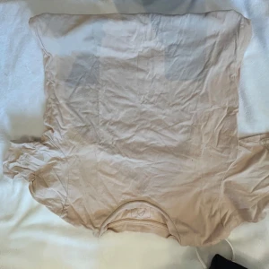 Beige t-shirt från APT - Säljer en enkel och stilren beige t-shirt från APT. Perfekt för en avslappnad look. T-shirten har korta ärmar och en rund halsringning. Den är aprikos beige