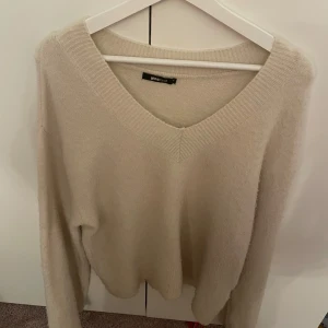 Stickad tröja  - Det är en uringad stickad tröja som är beige och är i storleken XS. Den kommer ifrån Gina tricot och jag säljer den för att den inte används. Köparen betalar för frakten. Skriv till mig innan du beställer. 