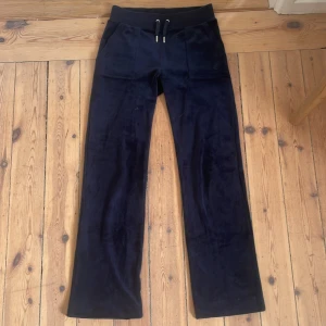  Juicy Couture Byxor - Säljer ett par mörk blå juicy byxor med snörning i midjan och fickor både fram och bak. De är tillverkade i ett mjukt material som ger en bekväm känsla. Är själv 165cm och sitter perfekt i längden på mig. (De är upplagda) jag har även tröjan uppe för försäljning. Nypris: 1200kr. Pris kan diskuteras 