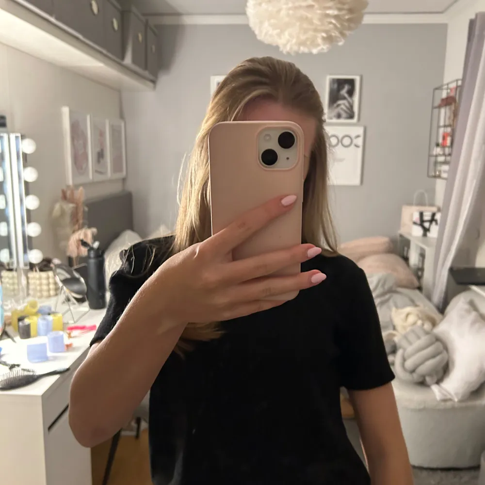 Säljer en stilren svart kortärmad topp. Perfekt för en enkel och klassisk look. Toppen har en normal passform och är tillverkad i ett mjukt material.. Yläosat.