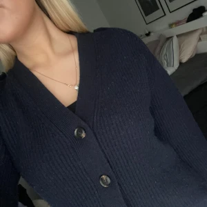 Massimo Dutti Mörkblå kofta - Säljer en stilren mörkblå kofta med knappar framtill. Koftan har en ribbad struktur och långa ärmar, perfekt för kyligare dagar. Passar bra till både jeans och kjol. Hör av dig vid intresse!