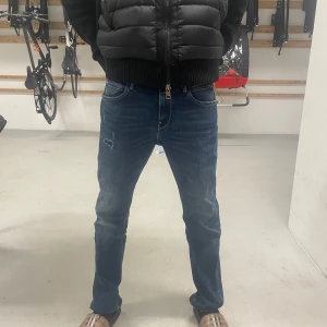 Mörkblå replay byxor - Snygga mörkblå jeans med en klassisk femficksdesign och slitna detaljer på framsidan. Byxorna har en dragkedja och knappstängning. Perfekta för en avslappnad stil.