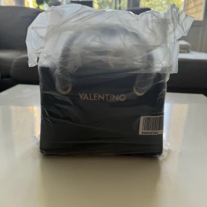 Valentino Bags ALEXIA - Handväska - nero - Snygg svart handväska med gulddetaljer och ett mönster på axelremmen. Väskan är i gott skick och har aldrig använts, original pris 1545 kr.