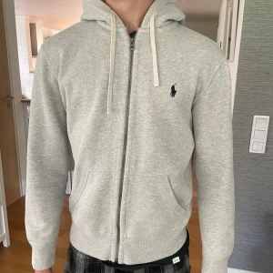 Ralph Lauren hoodie  - Säljer denna gråa Ralph Lauren zip i mycket bra skick!😝 Inga defekter Hästen är mörkblå