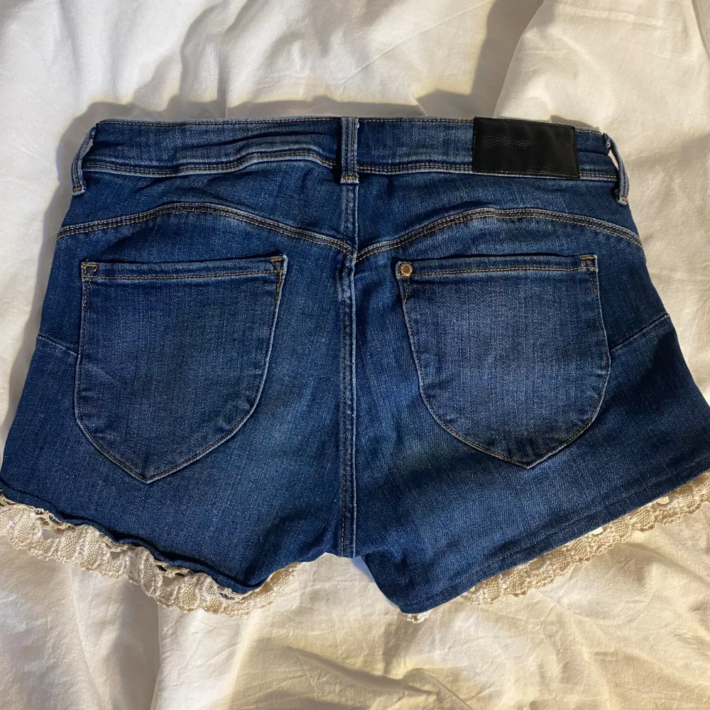 Lågmidjade jeansshorts med spets.. Shorts.