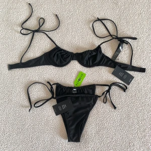 NA-KD svart bikini - Bikini från NA-KD. Bikiniunderdel i storlek S och överdel i storlek 75B. Ny med prislappar kvar.