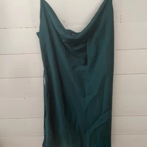 Grön satinklänning - Alltså drööömklänning, tyvärr fel storlek för mig:( den går att styla upp & ner skulle jag säga, och just denna gröna färg är ju så snygg året om! Har ett litet band som man antingen kan knyta runt midjan eller bak i ryggen för att få lite extra form