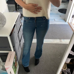 Blå jeans med bootcut - Säljer ett par snygga blå jeans med bootcut. De är i bra skick och har en klassisk femficksdesign med dragkedja och knapp. Perfekta för både vardag och fest!