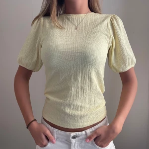 Gul topp med puffärm - Så fin och skön. Sitter tajt. Jag brukar ha storlek xs. 