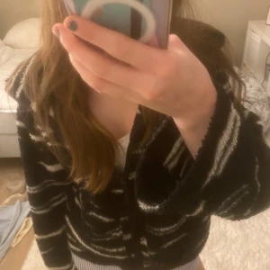 Svart och vit mönstrad tröja - Säljer en supermysig teddi jacka med zebramönster som ej går att köpa längre. Tröjan har långa ärmar och en skön passform. Perfekt för vardagen!