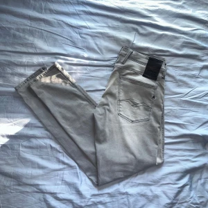 Grå Reaplay Jeans - Tja, jag säljer mina ljusgråa replay jeans som är perfekta nu till Hösten 🍁. Dom är i storlek W32 L32 och är i modellen anbass. Dom har blivit använda 3 gånger under vintern och har inga defekter och är i toppsick. Skriv till mig vid några frågor! 💬 