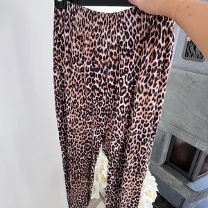Byxor i leopard - Ett par mjukisbyxor i leopardmönster från H&M. Resår i midja och i benslut. Storlek L och sanna i storlek 🤎  Innerbenslängd: 62 cm Midja: 89 cm