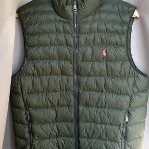 Polo Ralph Lauren väst  - Snygg väst från Polo Ralph Lauren i mörk grön färg, vilket passar bra till hösten. Västen är sparsamt använd och i väldig bra skick. 