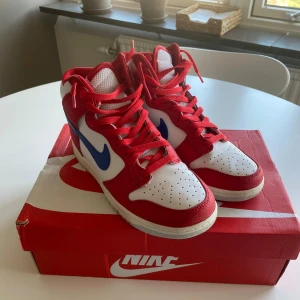 Nikeskor  - Nike Dunk Hi Retro skor i färgen white/game royal. Endast använda en gång. Säljer dessa då dem tyvärr inte kommer till användning. 