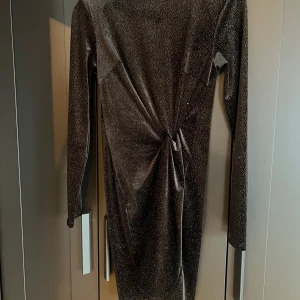 Glittrig klänning  - Glittrig, kort klänning från H&M. Aldrig använd, endast testad. Prislapp fortfarande kvar. Storlek S, normal i storleken.  150kr eller bud.