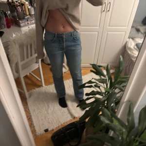 Blå jeans - Säljer ett par klassiska lite oversized  blå jeans med normal passform. De har en enkel design med fem fickor och knappgylf. Perfekta för en avslappnad stil.