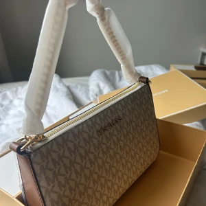 HELT NY MICHAEL KORS VÄSKA - Snygg beige axelväska från Michael Kors, man får med matchande kortfodral. Väskan har ett stilrent MK-mönster. Helt ny & oanvänd 💕(Skriv gärna för frågor) Kan diskutera pris vid intresse och SNABB affär!