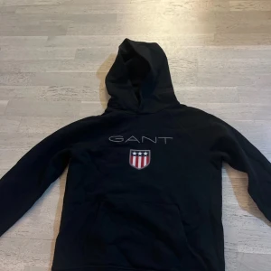 Svart hoodie från GANT - Säljer en svart hoodie från GANT i storleken 158-164 i barn storlek. Använt bara 1 gång