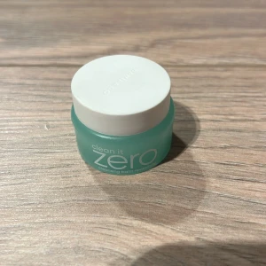 Clean It Zero Cleansing Balm - Säljer en liten burk av Clean It Zero Cleansing Balm från Banila Co. Denna rengöringsbalm är perfekt för att ta bort smink och orenheter. Kommer i en turkos burk med vitt lock. Perfekt för resor eller att testa produkten innan köp av fullstorlek.
