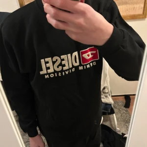 Snygg tröja från diesel - Säljer en svart sweatshirt från Diesel med tryck på framsidan. Tröjan har långa ärmar och använd 1 gång. Passar mig och jag är 170