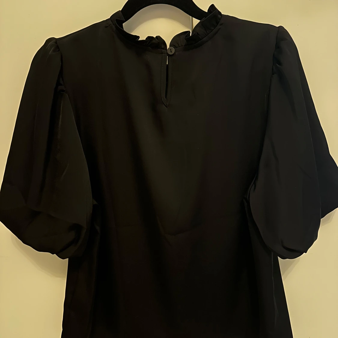 Svart blus med blommiga detaljer - 1