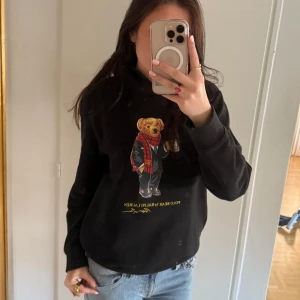 Svart hoodie Ralph Lauren - Säljer en svart hoodie från Ralph Lauren med det i Polo bear🐻✨. Det kommer tyvärr inte till någon användning och är använd fåtals gånger. Själv är jag i storlek S och hoodien sitter bra på. Priset kan diskuteras💕