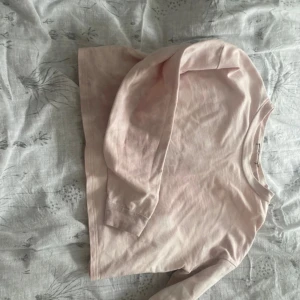 Ljusrosa långärmad tröja - Säljer en ljusrosa långärmad tröja i bomull. Perfekt för en avslappnad stil. Tröjan har en enkel design med rund hals och är skön att bära.