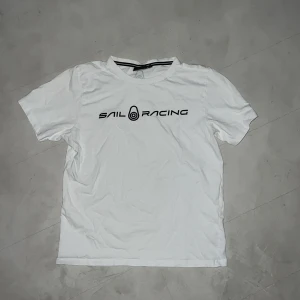 SAIL RACING T-shirt  - En vit SR t-shirt med svart text på bröstet. Bra kvalitet köpt från Sail Racing i strl 170 