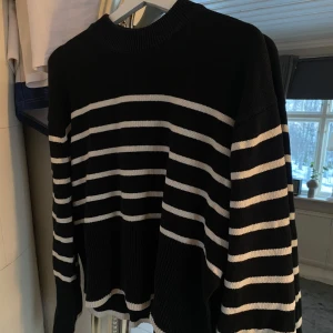 Stickad tröja - En svart och vit randig stickad tröja från Gina tricot med slits på sidan i storlek S.