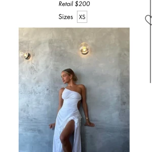 Vit axelbandslös klänning - Säljer denna fina klänning inköpt förra sommaren från sndys, inköpt för 1500 kr. Klänningen är använd bara 1 gång så i väldigt fint skick. Materialet är lite mjukare och är väldigt skön att ha på. Klänningen är öppen i ryggen och lång i modellen. Bild 3&4 är mina egna bilder