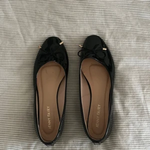 Svarta ballerinaskor från Jenny Fairy - Snygga svarta ballerinaskor i lack från Jenny Fairy. Lite tecken på användning ex där lite lack försvunnit, men är i mycket bra skick! Storlek 36