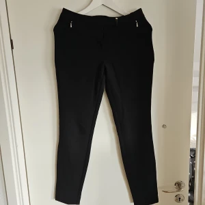 Svarta byxor med dragkedja - Snygga svarta byxor med dragkedja och smal passform. Perfekta för en stilren look.