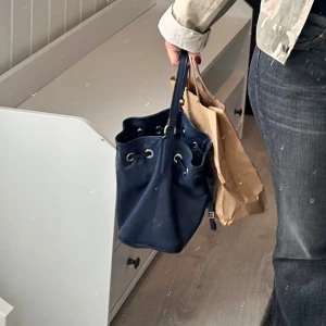 Blå skinnväska från Gianni Chiarini - Snygg blå skinnväska från Gianni Chiarini, tillverkad i Italien. Väskan har en praktisk dragsko och stilrena metalldetaljer. Perfekt för att ge din outfit en touch av elegans. 👜✨äkta läder