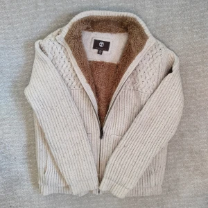 Päls fodrad Timberland cardigan  - Säljer en stickad cardigan med pälsfodring från märket Timberland. Väldigt tjock och varm, med en elegant, stilren och komfortabel design. Tveka inte att höra av dig vid minsta fundering!