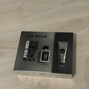 La Rive 315 Prestige Black för män - Upptäck La Rive 315 Prestige Black för män, ett set med Eau de Toilette och duschgel. Flaskan har en elegant svart design med tydlig text och innehåller 100 ml doft. Duschgelen kommer i en stilren grå tub på 100 ml. Perfekt för den moderna mannen som vill ha en sofistikerad doft. Och en perfekt schampo och parfym till sommaren.