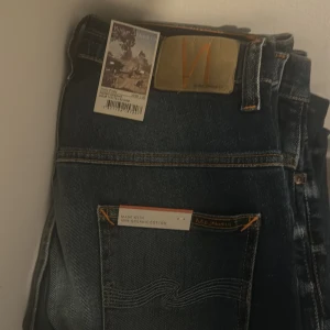 Blå jeans från Nudie Jeans w29L30  - Snygga blå jeans från Nudie Jeans i 100% ekologisk bomull. De har en klassisk femficksdesign och en snygg tvätt med lätt slitna detaljer. Perfekta för en avslappnad stil.