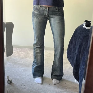 Blå bootcut jeans  - Snygga blå bootcut jeans med broderade detaljer på bakfickorna. 